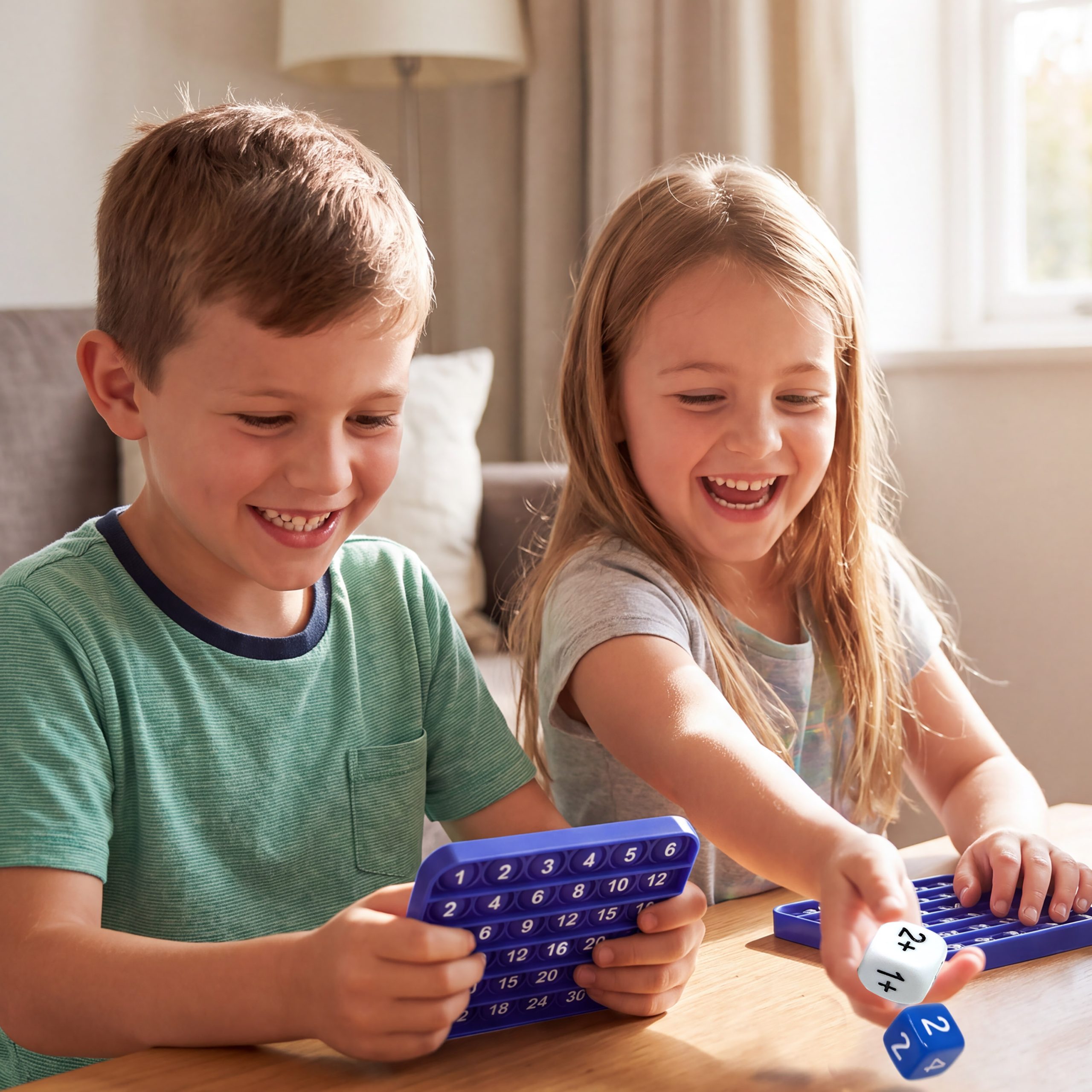 Two children playing ArithMatrix math game with silicone pop mats
